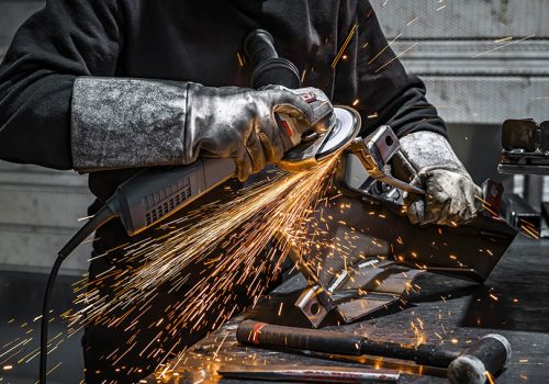 View of worker grinding a piece of metal, France