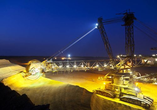 A lignite surface mine with a giant bucket-wheel excavator, one of the worlds largest moving land vehicles with night blue sky.
